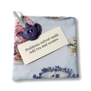 Fabric bag with decorative ribbon and button, and tag with inspirational quote.