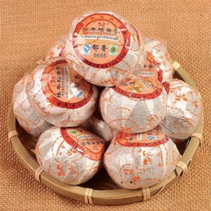 Round bamboo tray with several individually wrapped Golden Horse Ripe Puerh tea.